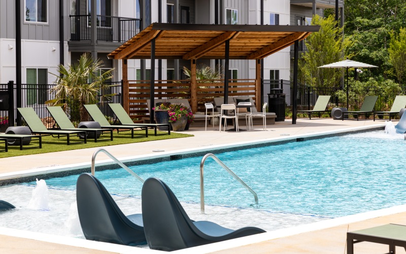 Resort-style pool with sundeck & pergolas at Ava Oakwood apartments in Gainesville, GA