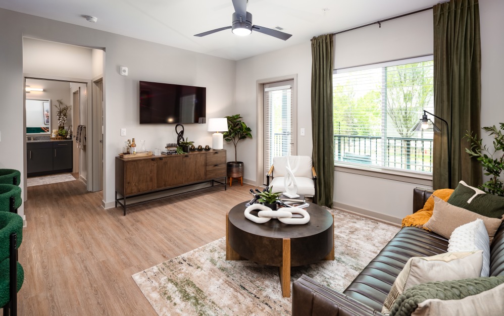 Furnished living room with large window at Ava Oakwood pet-friendly apartments in Gainesville