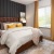Furnished bedroom with brown accent wall at Ava Oakwood apartments in Gainesville